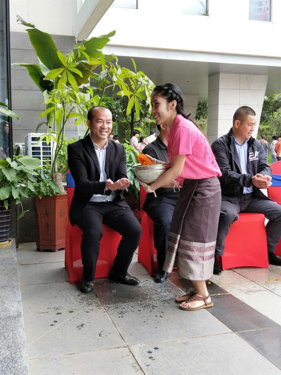 老撾駐廣西留學(xué)生代表將浸有花瓣的香水灑客人的手上，表示對(duì)嘉賓的美好祝福（圖一）
