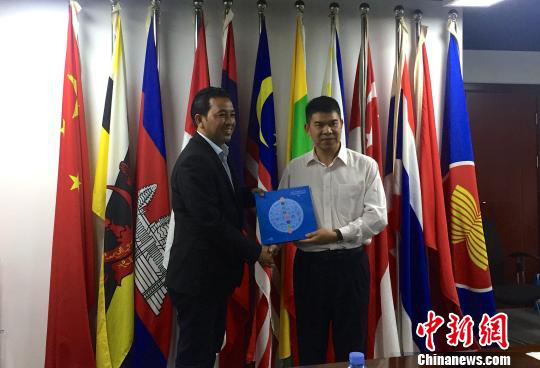 中國—東盟博覽會(huì)秘書處副秘書長黃平西（右）與柬埔寨新聞部新聞與傳播總司副總司長春占皮侖（左）互贈(zèng)禮物。