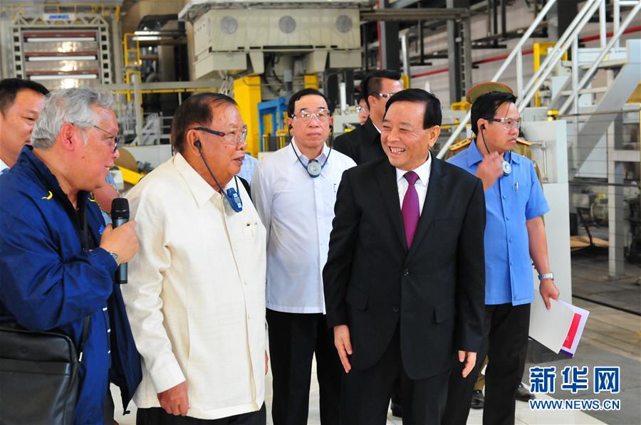 3月10日，在老撾沙灣拿吉省車邦縣，老撾人民革命黨中央總書記、國家主席本揚（左二）在山東太陽紙業(yè)股份有限公司董事長李洪信（右二）的陪同下視察公司。 新華社記者章建華攝